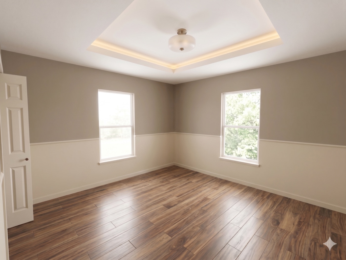 Clean staged bedroom with tray ceiling and refinished wood floor after renovation